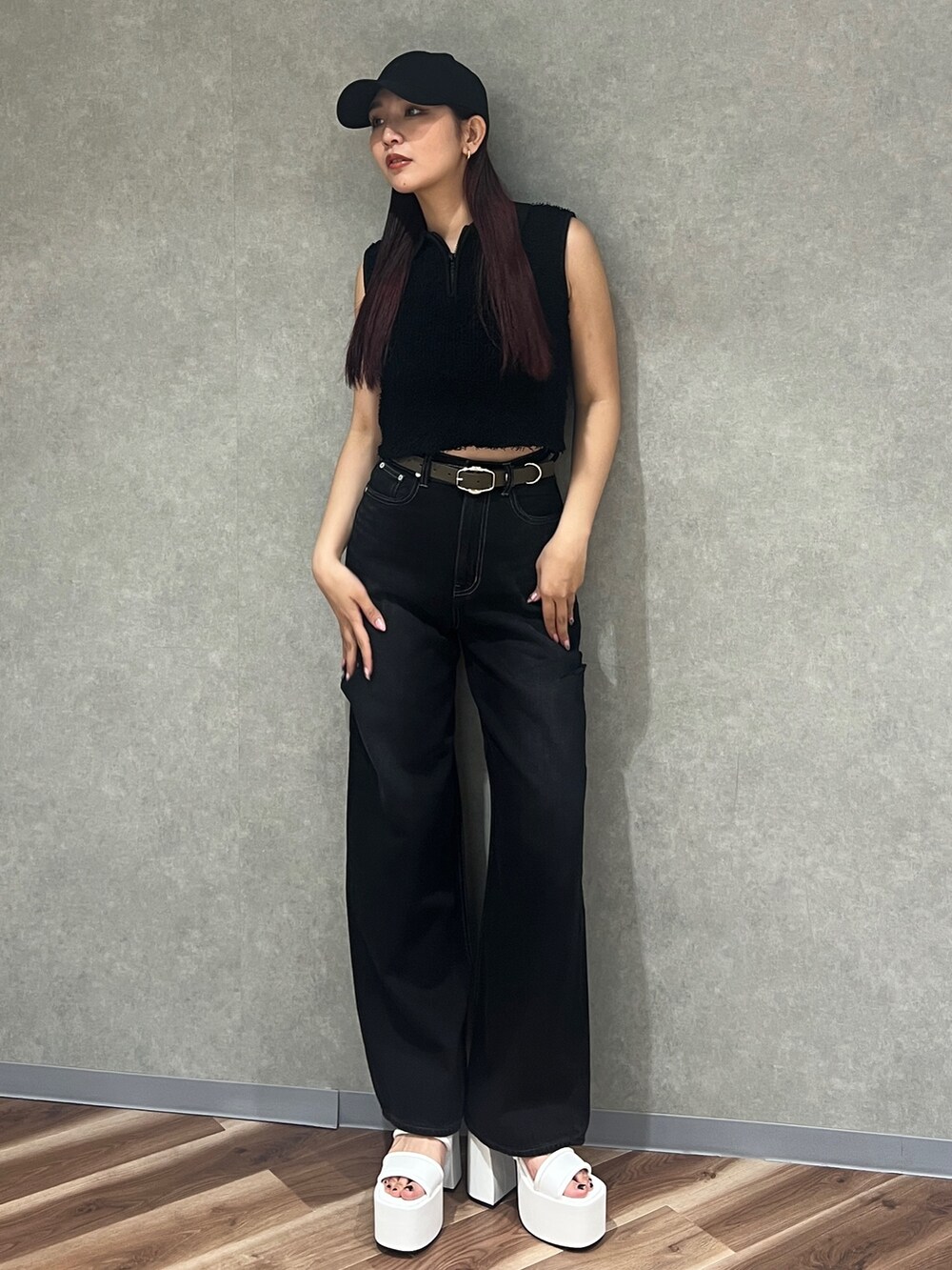 ブラック系のタンクトップ、ブラック系のデニムパンツ、ホワイト系のサンダルを着用したレディースの夏コーディネートの5枚目の写真