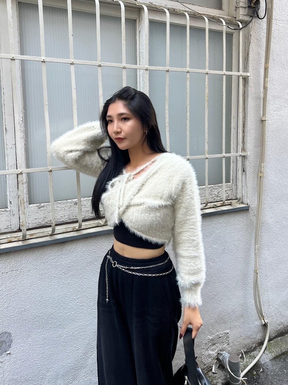 ブラック系のスウェットパンツ、ブラウン系のブーツ、ブラック系のキャミソールを着用したレディースの秋コーディネートの4枚目の写真