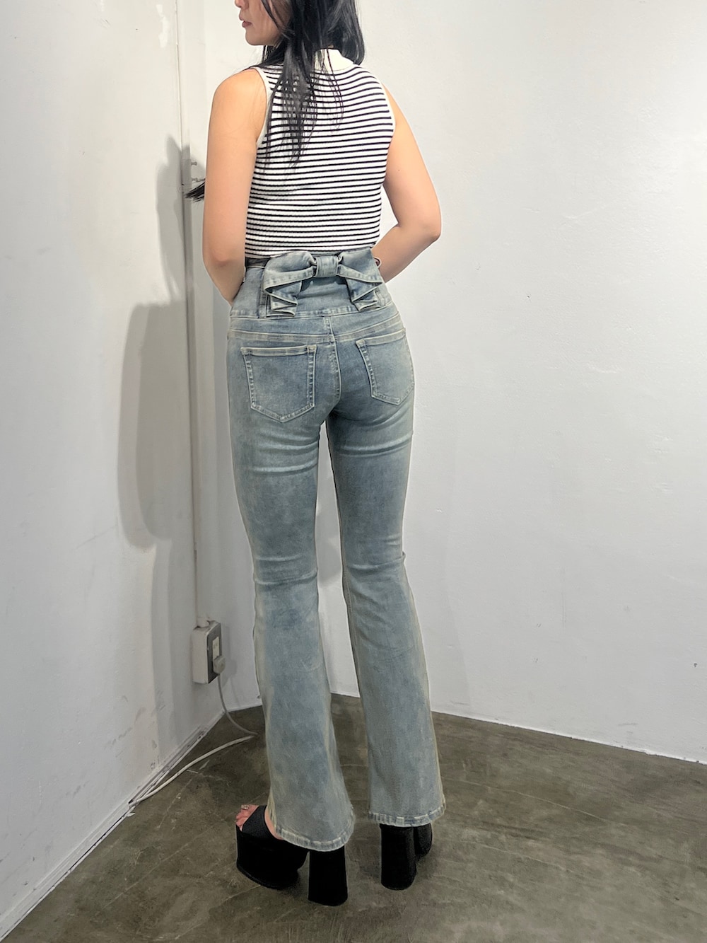 ブルー系のデニムパンツ、ブラック系のサンダルを着用したレディースの春コーディネートの3枚目の写真