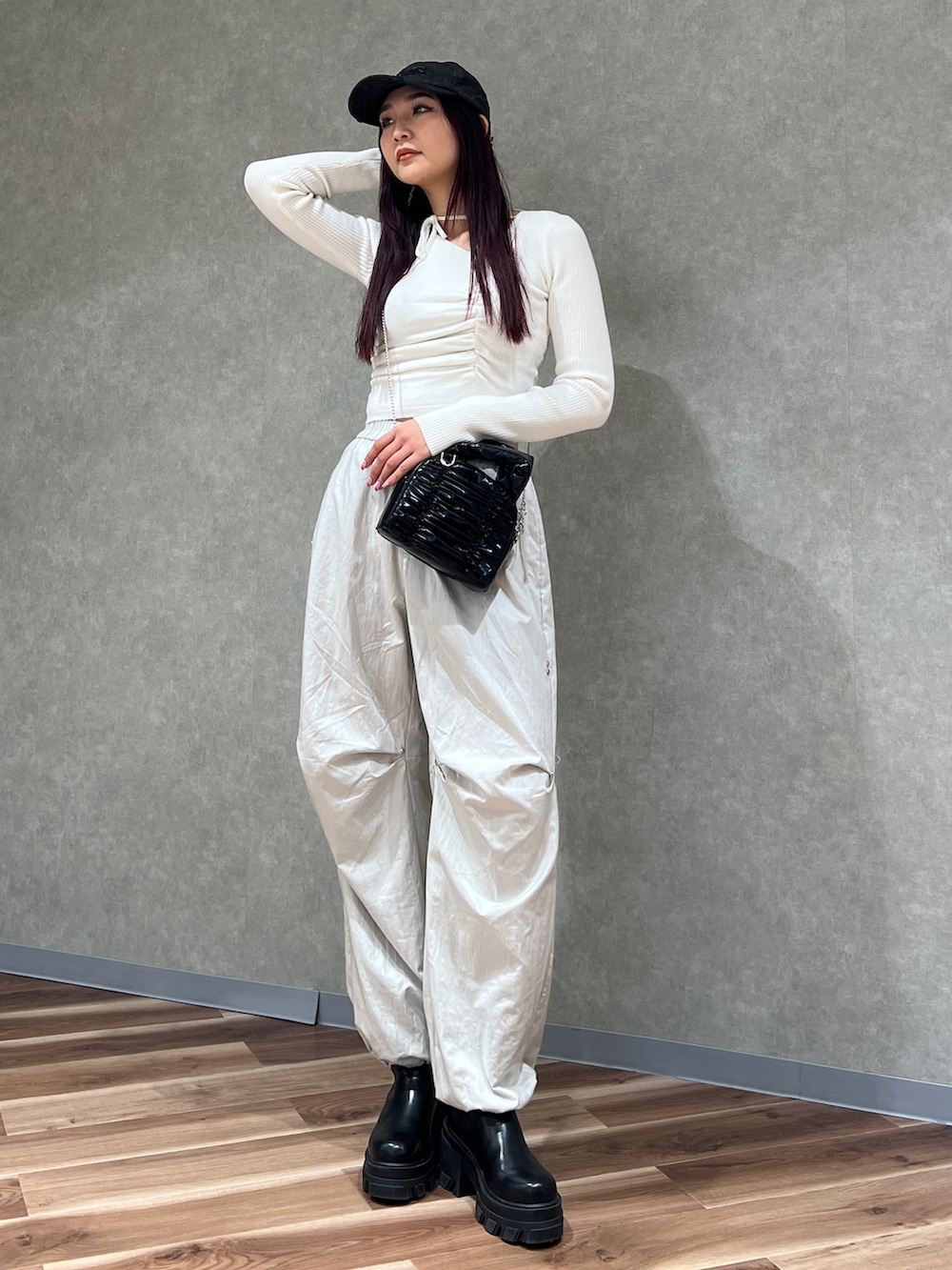 ホワイト系のニット/セーター、ホワイト系のその他パンツ、ブラック系のハンドバッグを着用したレディースの冬コーディネートの2枚目の写真