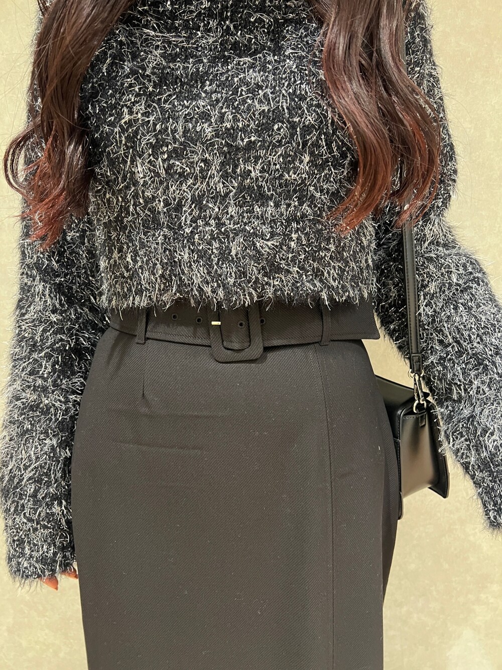 ブラック系のニット/セーター、ブラック系のスカート、ブラック系のブーツを着用したレディースの冬コーディネートの5枚目の写真