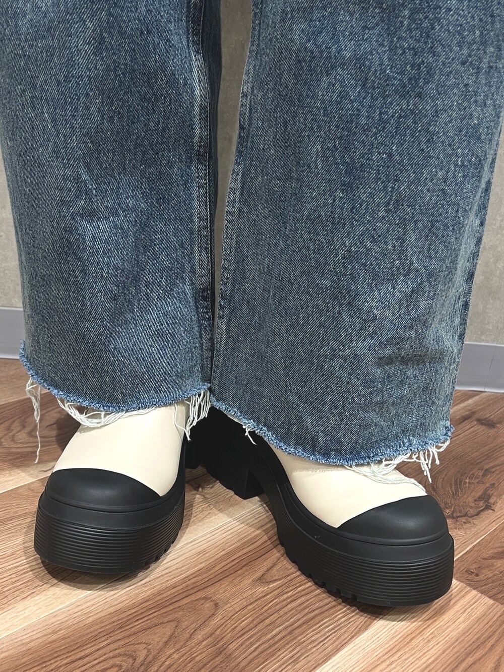 グレー系のニット/セーター、ブルー系のデニムパンツ、ホワイト系のブーツを着用したレディースの秋コーディネートの8枚目の写真