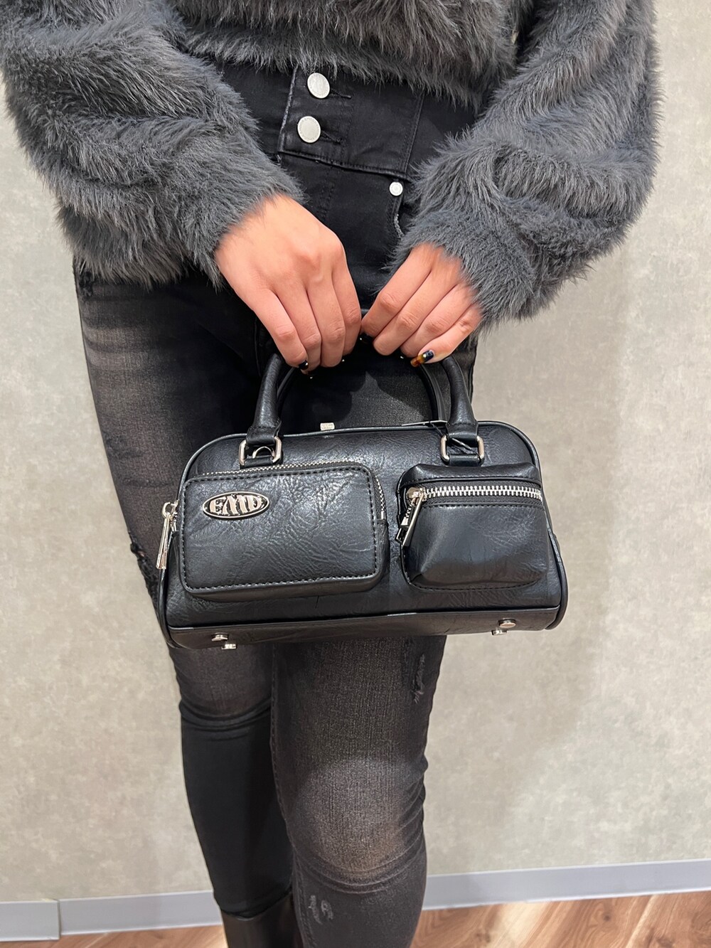 グレー系のニット/セーター、ブラック系のデニムパンツ、ブラック系のブーツを着用したレディースの秋コーディネートの8枚目の写真