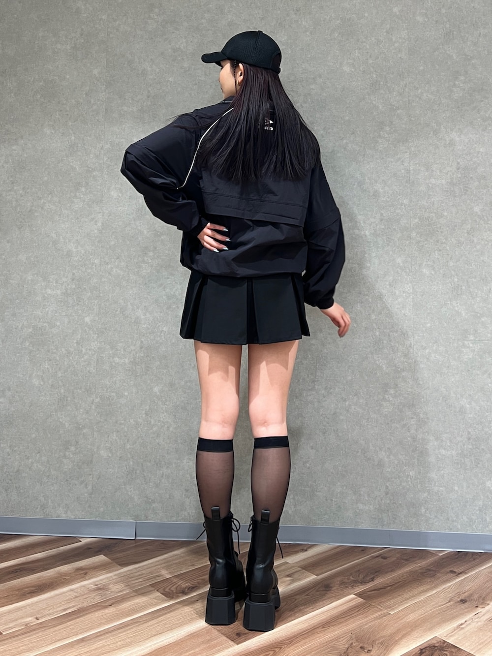 ブラック系のブルゾン、ブラック系のスカート、ブラック系のブーツを着用したレディースの春コーディネートの4枚目の写真