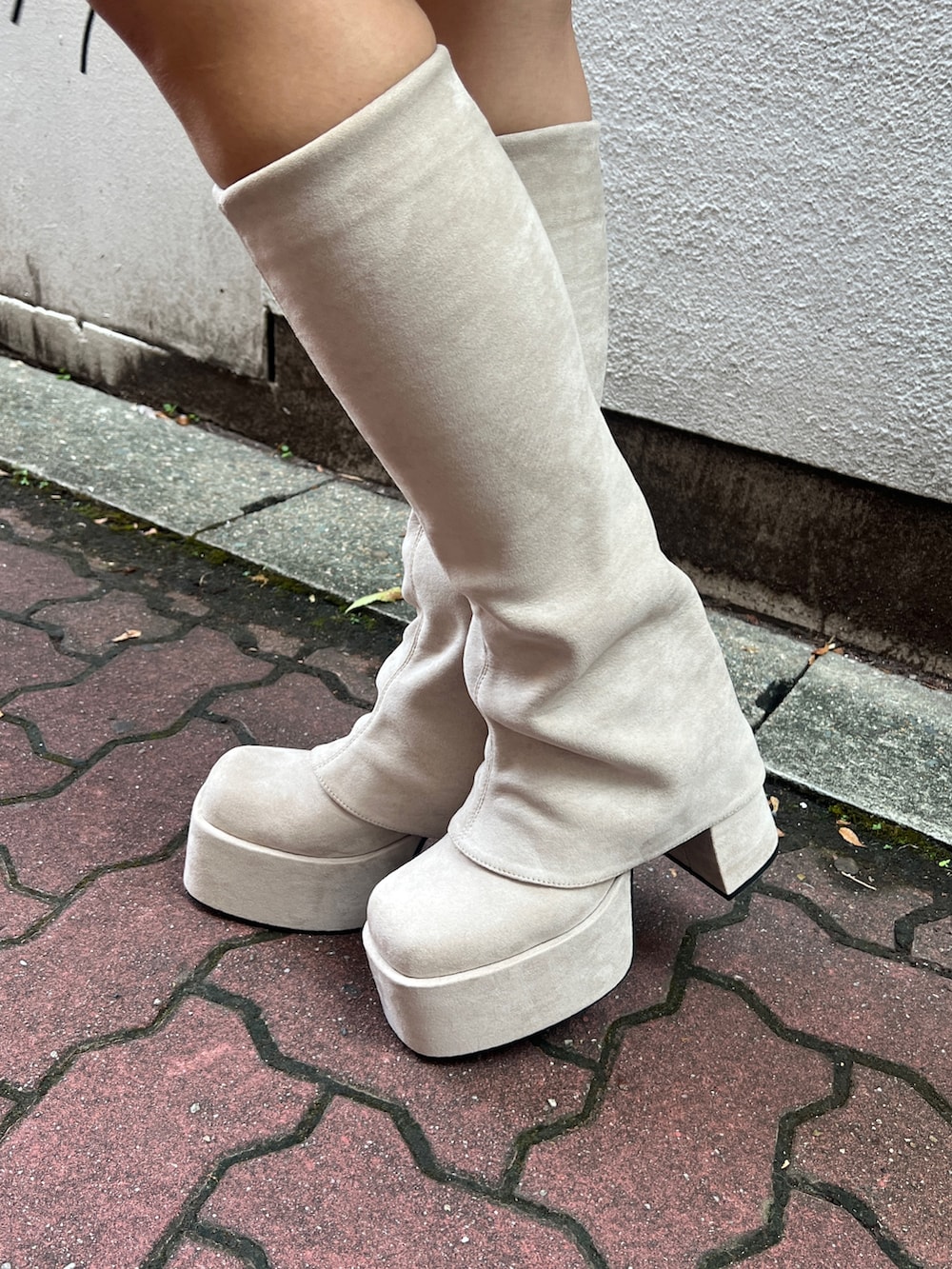 ホワイト系のダウンベスト、ホワイト系のニット/セーター、ブラウン系のその他パンツを着用したレディースの秋コーディネートの6枚目の写真