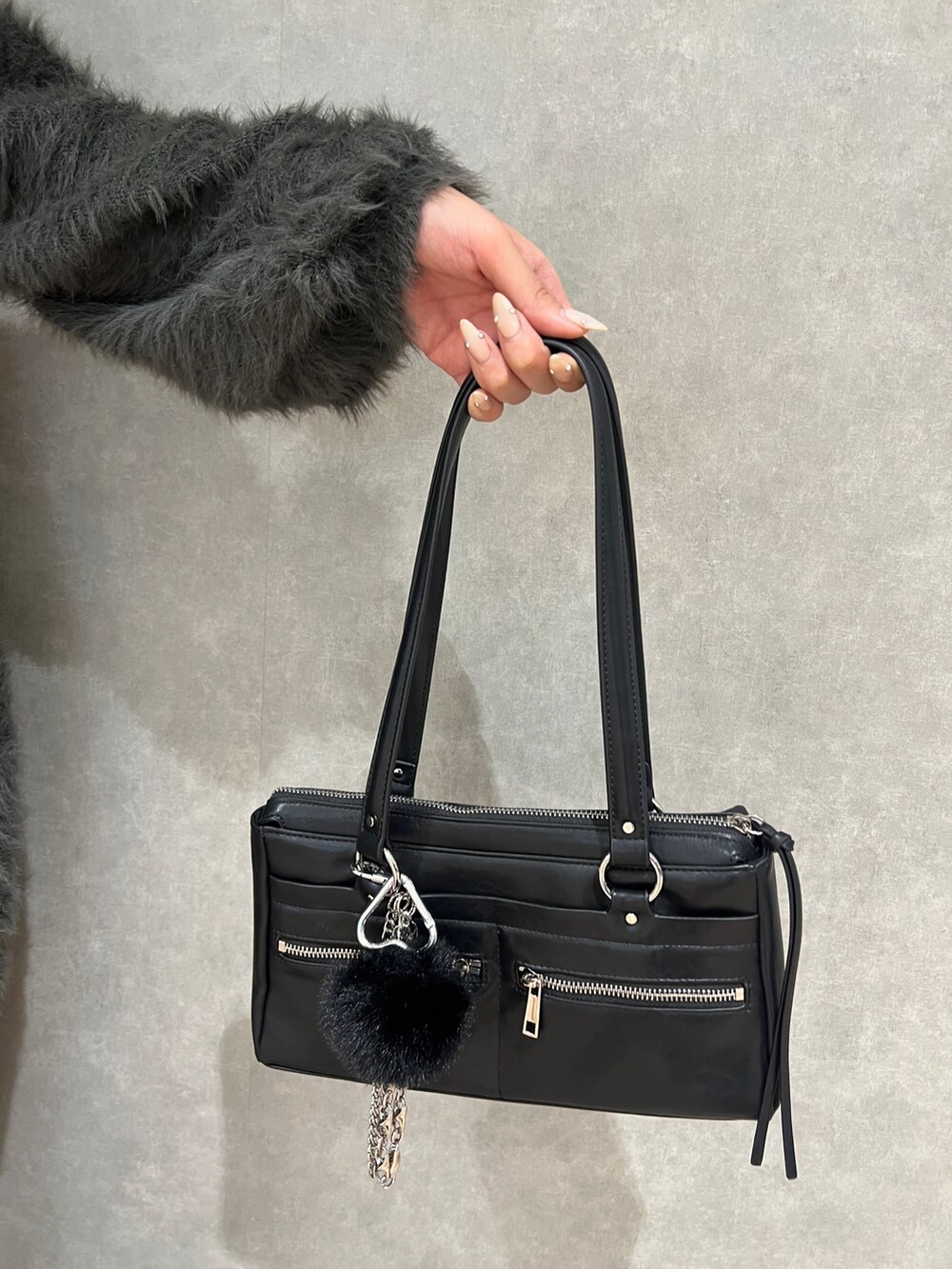 グレー系のワンピース、ブラック系のショルダーバッグ、ブラック系のブーツを着用したレディースの秋コーディネートの6枚目の写真