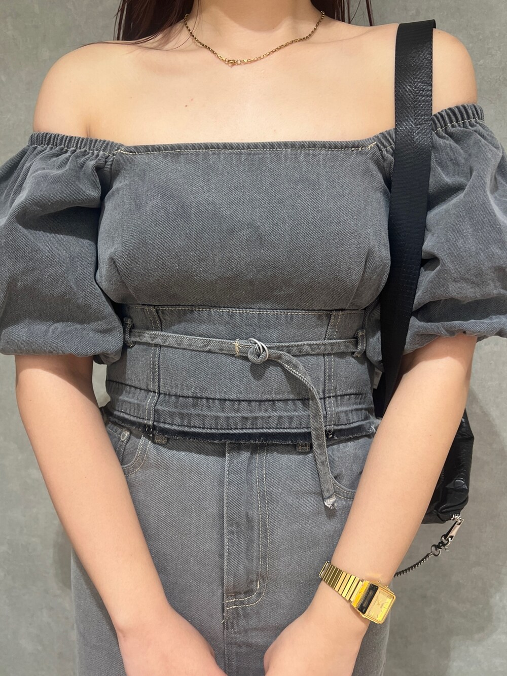 ブラック系のサンダル、グレー系のスカート、ブラック系のハンドバッグを着用したレディースの春コーディネートの4枚目の写真