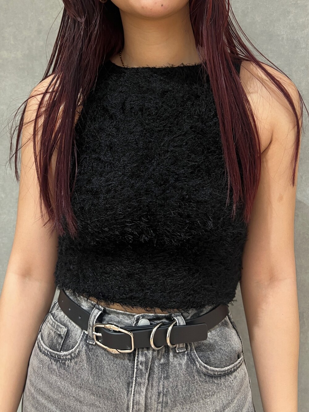 ブラック系のタンクトップ、ブラック系のスカート、ブラック系のブーツを着用したレディースの春コーディネートの6枚目の写真