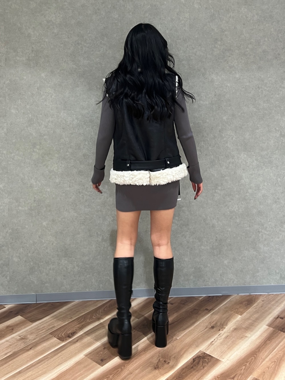 ブラック系のムートンコート、ブラック系のブーツ、グレー系のワンピースを着用したレディースの秋コーディネートの3枚目の写真