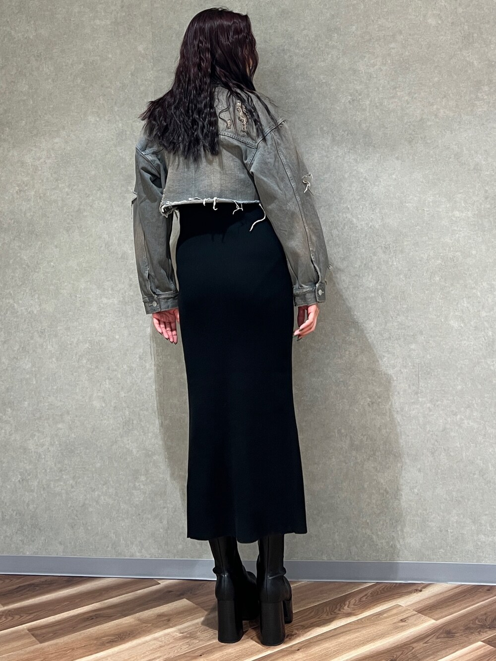 グレー系のデニムジャケット、ブラック系のワンピース、ブラック系のブーツを着用したレディースの冬コーディネートの3枚目の写真