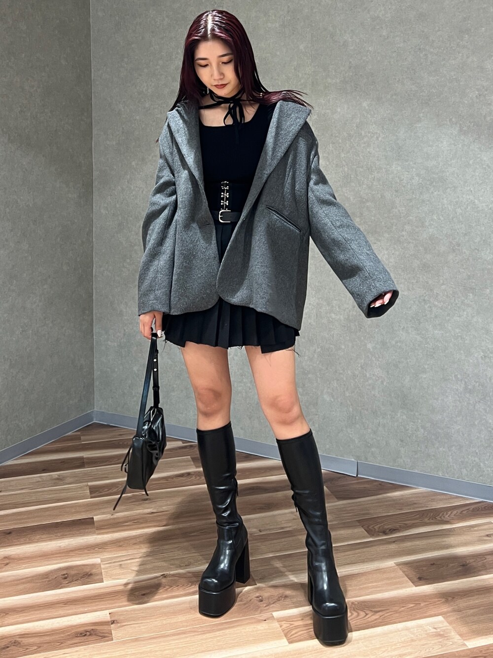 ブラック系のニット/セーター、グレー系のテーラードジャケット、ブラック系のスカートを着用したレディースの秋コーディネートの2枚目の写真