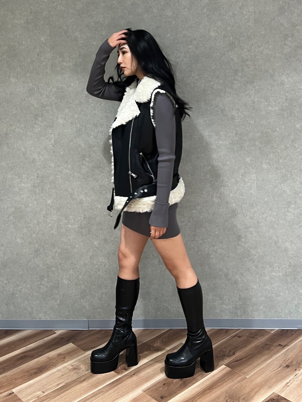 ブラック系のムートンコート、ブラック系のブーツ、グレー系のワンピースを着用したレディースの秋コーディネートの2枚目の写真