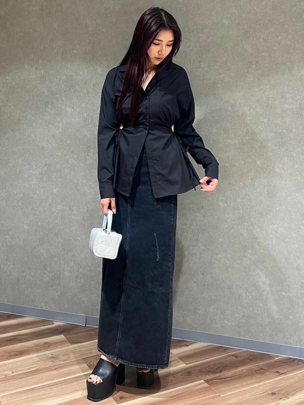 ブラック系のシャツ/ブラウス、ブラック系のスカート、グレー系のハンドバッグを着用したレディースの夏コーディネートの2枚目の写真