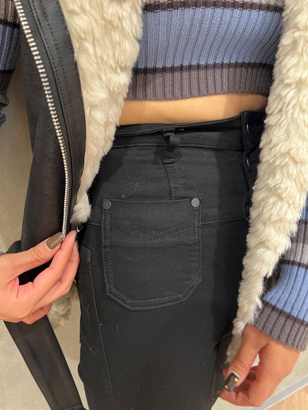 ブラック系のデニムパンツ、ブラック系のムートンコート、その他のニット/セーターを着用したレディースの秋コーディネートの6枚目の写真