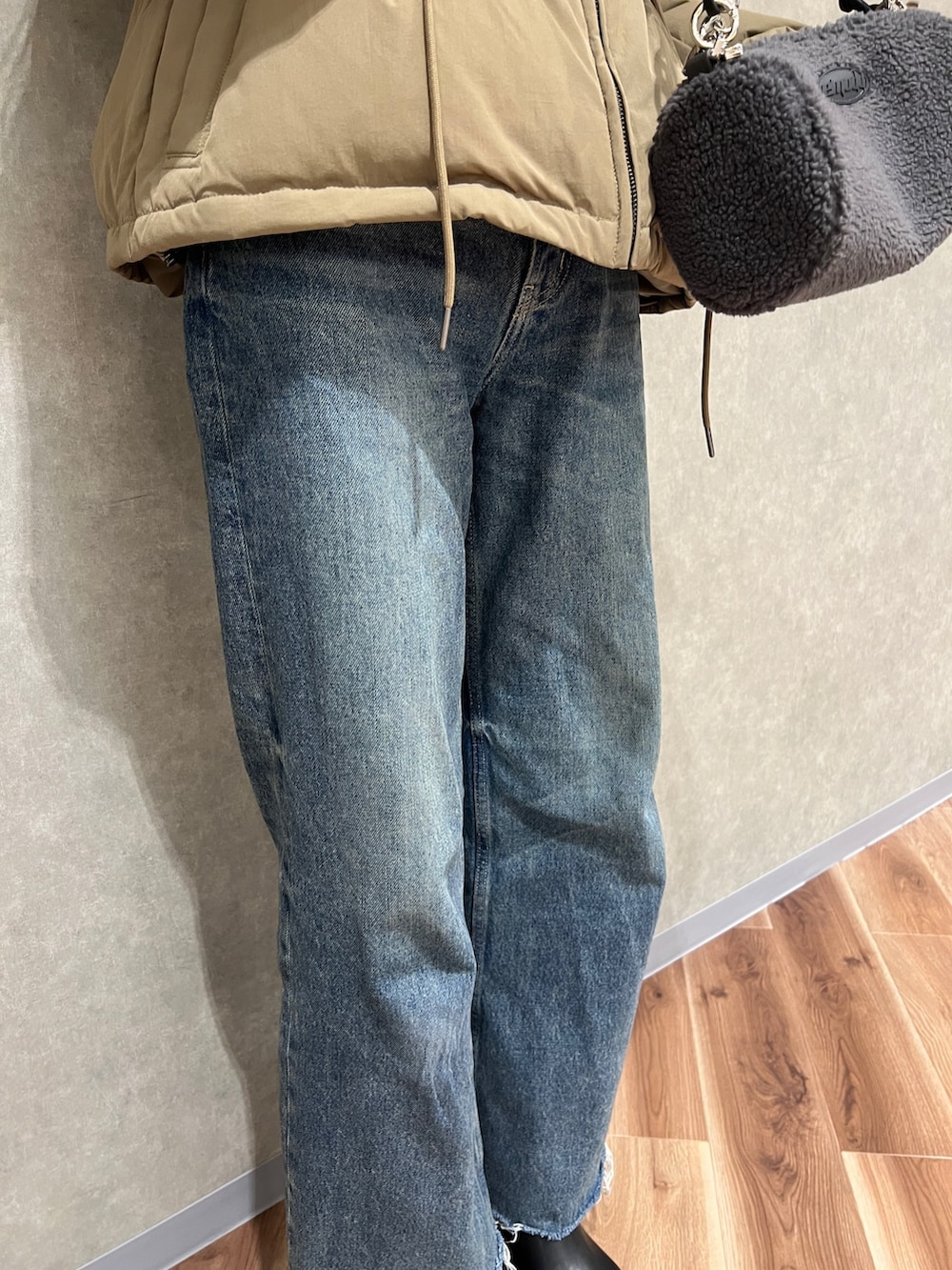 グリーン系のブルゾン、ブルー系のデニムパンツ、ブラック系のブーツを着用したレディースの秋コーディネートの5枚目の写真