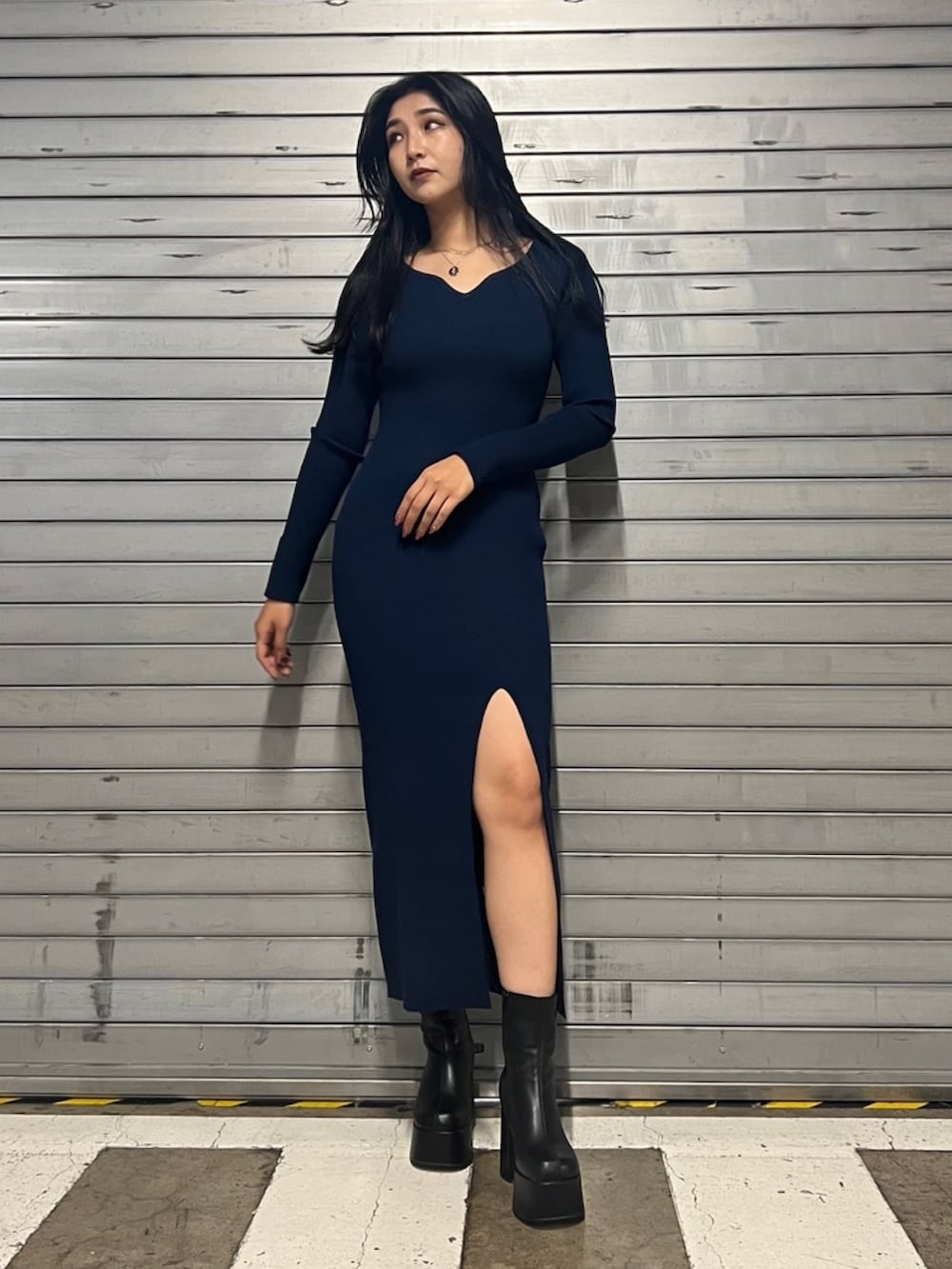 ブルー系のワンピース、ブラック系のブーツ、ゴールド系のネックレスを着用したレディースの秋コーディネートの2枚目の写真