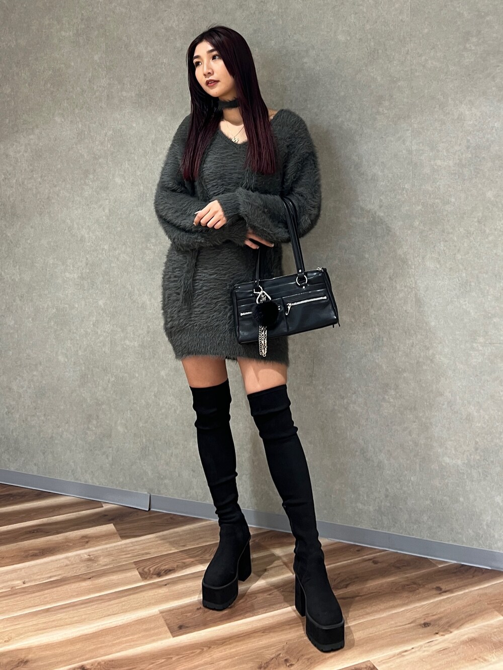 グレー系のワンピース、ブラック系のショルダーバッグ、ブラック系のブーツを着用したレディースの秋コーディネートの2枚目の写真