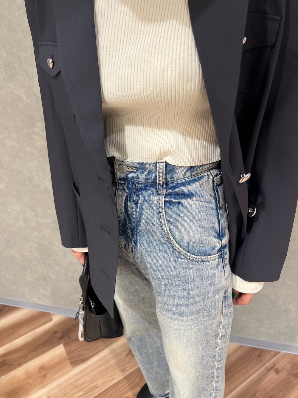 グレー系のテーラードジャケット、ブルー系のデニムパンツ、ブラック系のブーツを着用したレディースの冬コーディネートの6枚目の写真