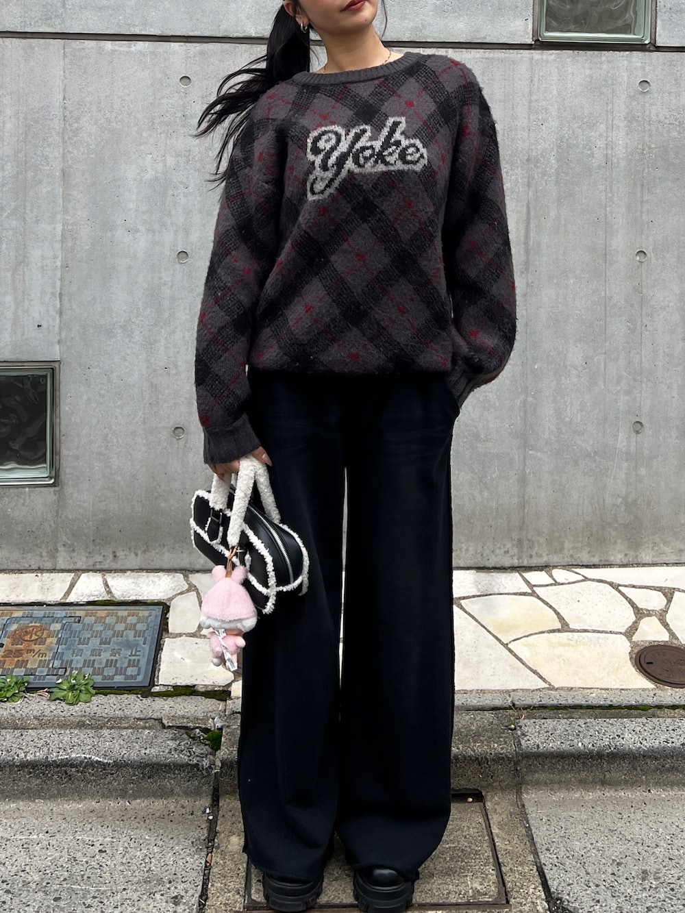 グレー系のニット/セーター、ブラック系のスウェットパンツ、ブラック系のブーツを着用したレディースの秋コーディネートの2枚目の写真