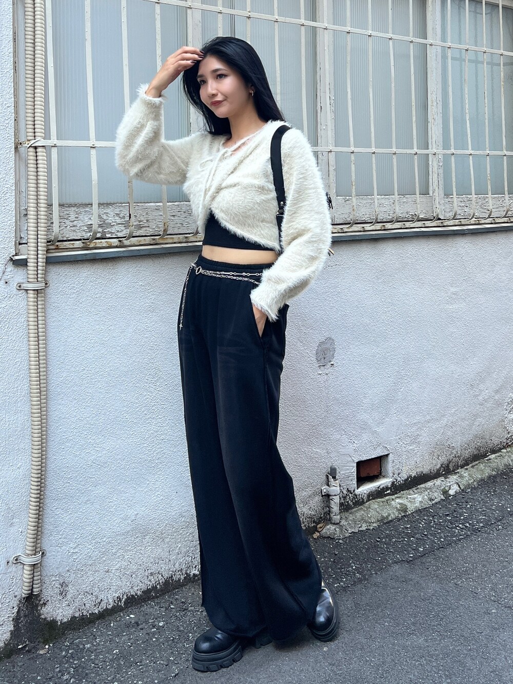 ブラック系のスウェットパンツ、ブラウン系のブーツ、ブラック系のキャミソールを着用したレディースの秋コーディネートの2枚目の写真