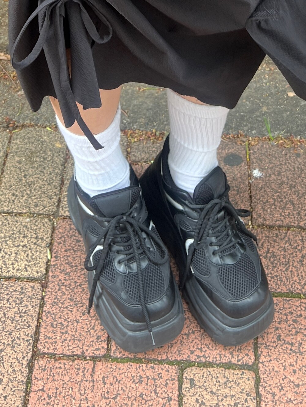 ホワイト系のTシャツ/カットソー、ブルー系のデニムパンツ、ブラック系のスニーカーを着用したレディースの春コーディネートの5枚目の写真