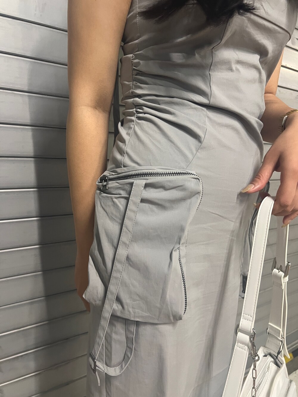 グレー系のワンピース、ホワイト系のハンドバッグ、ブラック系のサンダルを着用したレディースの夏コーディネートの6枚目の写真