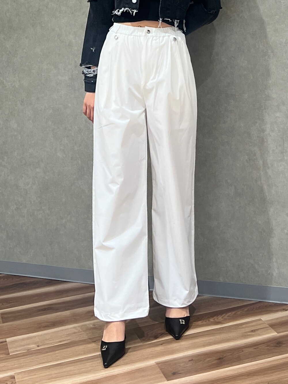 ブラック系のデニムジャケット、ブラック系のキャミソール、ホワイト系のその他パンツを着用したレディースの春コーディネートの3枚目の写真