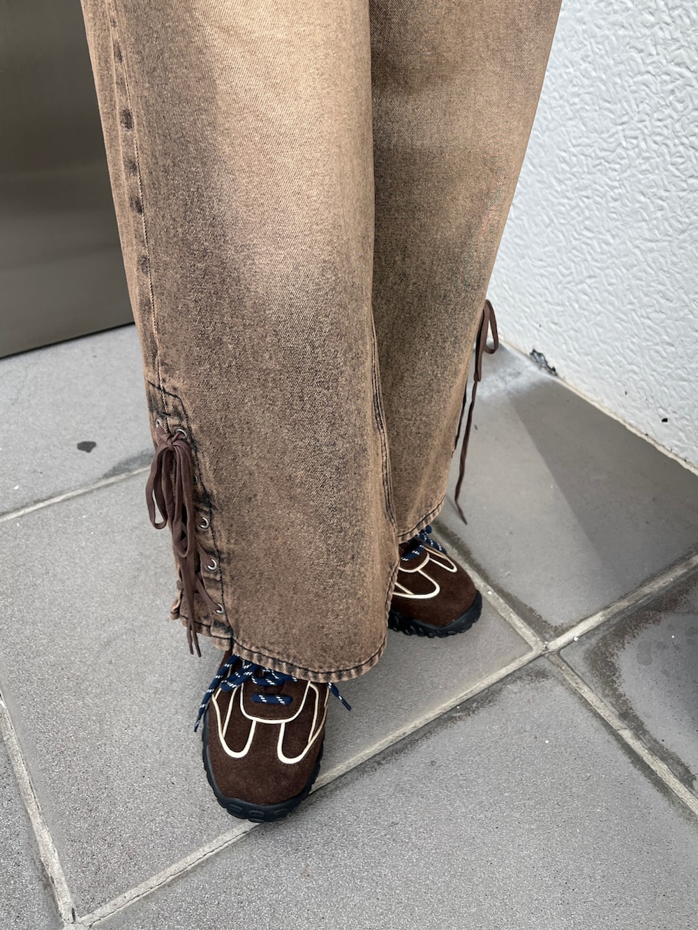 ブラウン系のタンクトップ、ブラウン系のデニムパンツ、ブラウン系のスニーカーを着用したレディースの春コーディネートの4枚目の写真