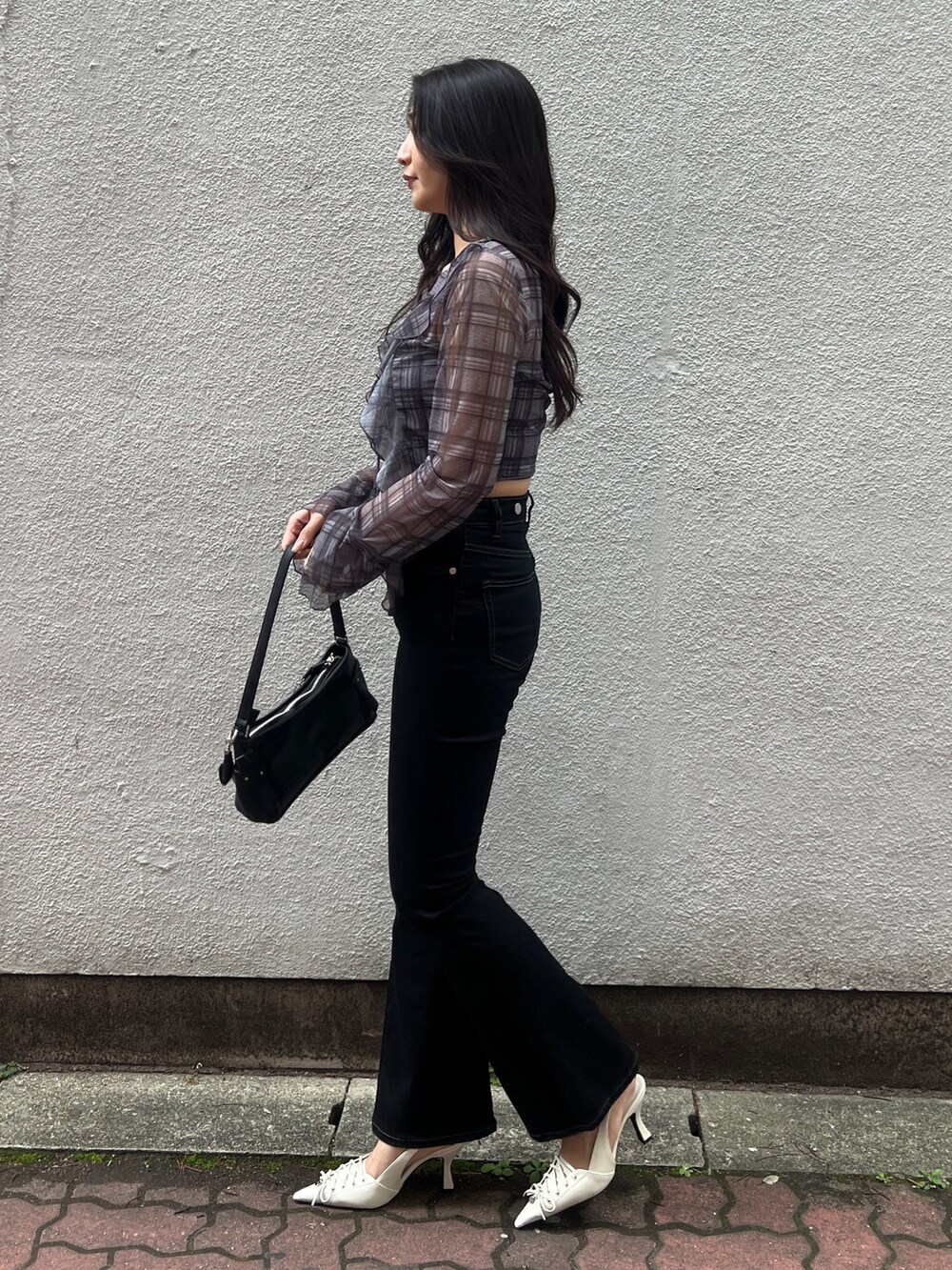 グレー系のシャツ/ブラウス、ブラック系のサロペット/オーバーオール、ホワイト系のパンプスを着用したレディースの春コーディネートの2枚目の写真