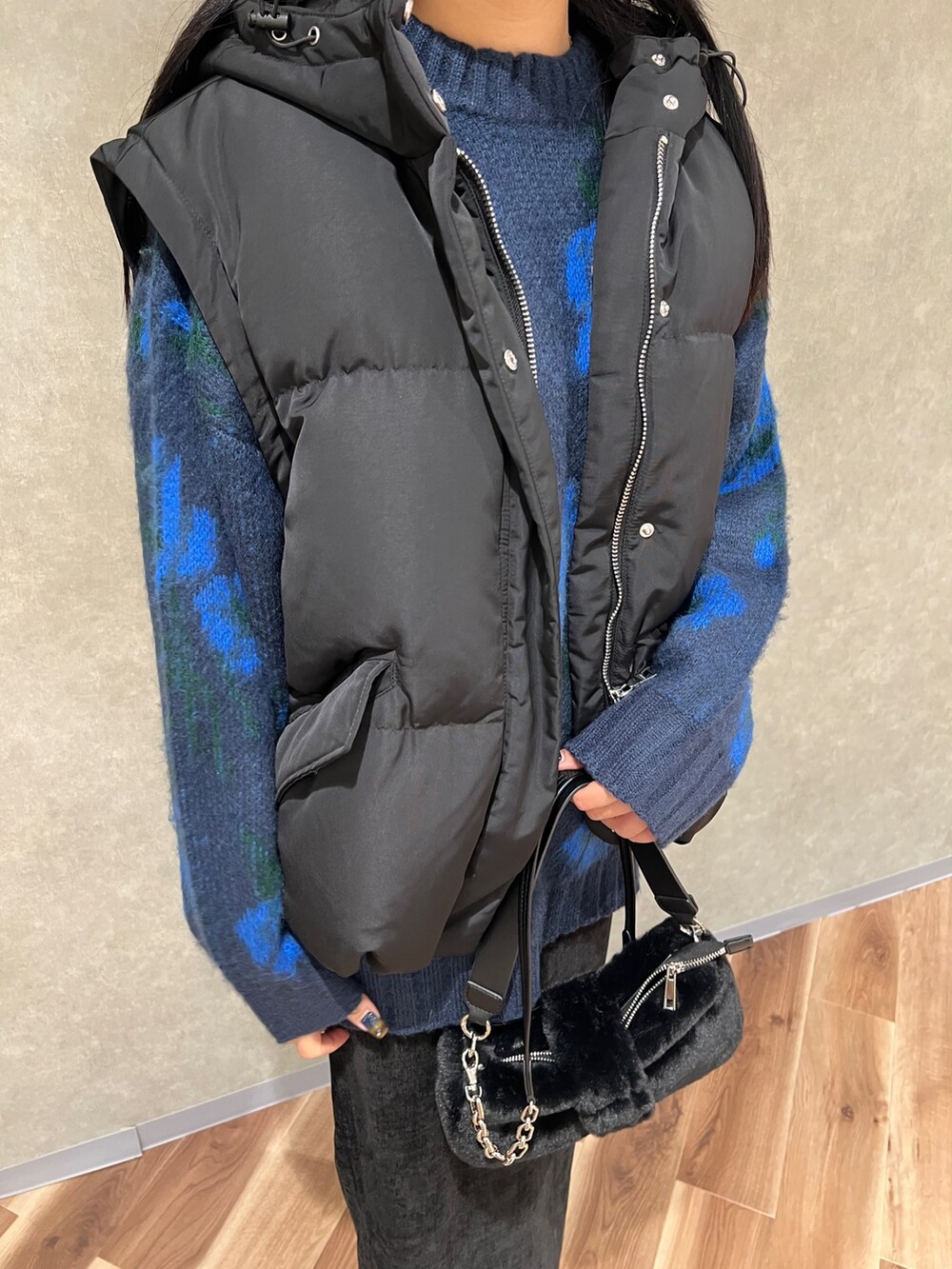 ブルー系のニット/セーター、ブラック系のブルゾン、ブラック系のスカートを着用したレディースの秋コーディネートの5枚目の写真