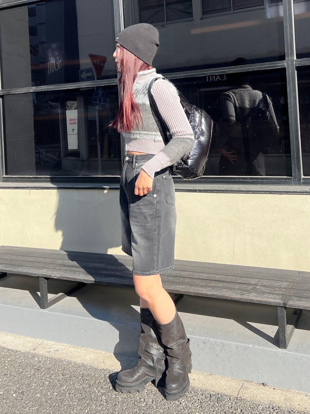 ブラック系のデニムパンツ、ブラック系のブーツ、シルバー系のボストンバッグを着用したレディースの冬コーディネートの2枚目の写真