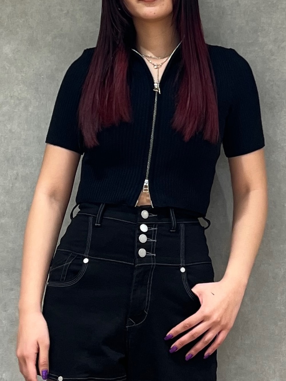 ブラック系のデニムパンツ、ブラック系のニット/セーター、ブラック系のパンプスを着用したレディースの春コーディネートの2枚目の写真