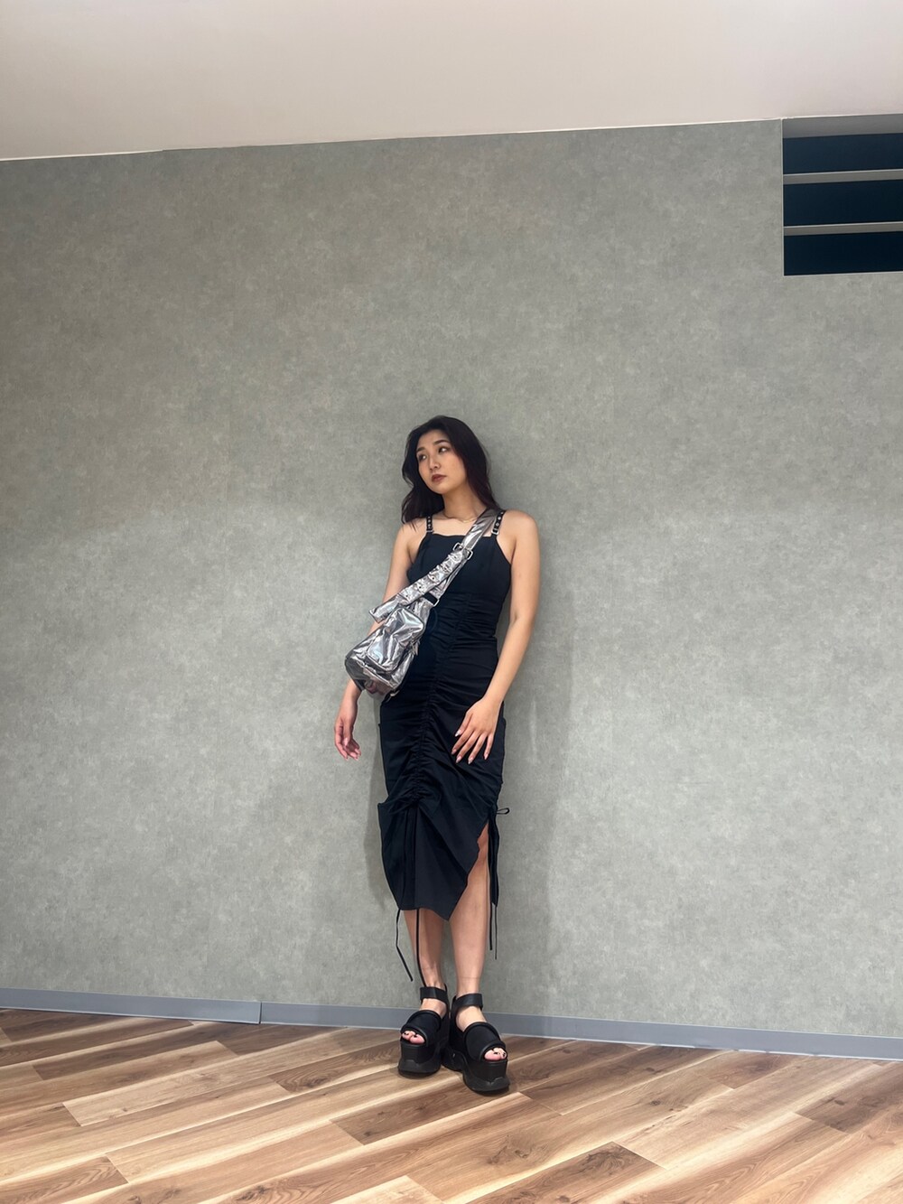 ブラック系のワンピース、シルバー系のハンドバッグ、ブラック系のサンダルを着用したレディースの夏コーディネートの5枚目の写真