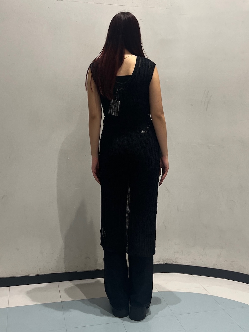 ブラック系のタンクトップ、ブラック系のワンピース、ブラック系のデニムパンツを着用したレディースの春コーディネートの5枚目の写真