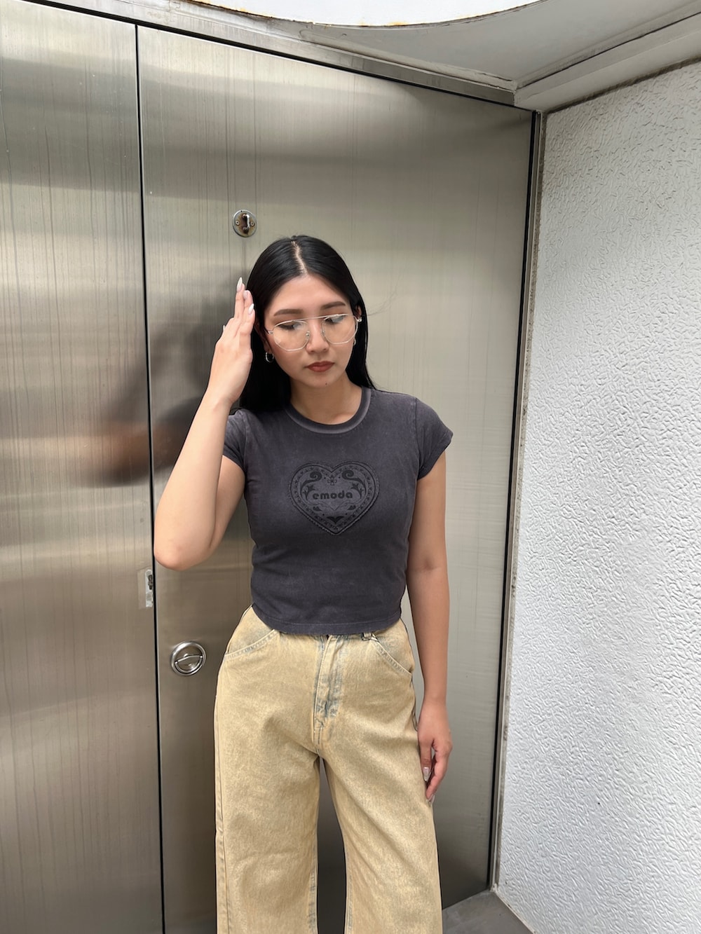 ブラック系のTシャツ/カットソー、ベージュ系のデニムパンツ、ブラック系のサンダルを着用したレディースの夏コーディネートの5枚目の写真