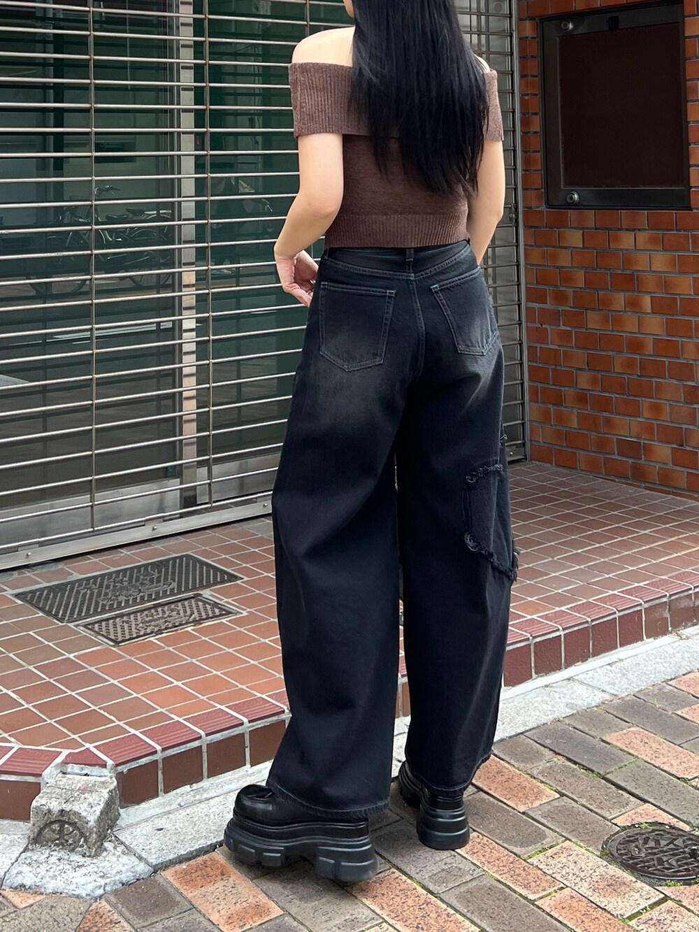 ブラウン系のニット/セーター、ブラック系のデニムパンツ、ブラック系のローファーを着用したレディースの夏コーディネートの2枚目の写真