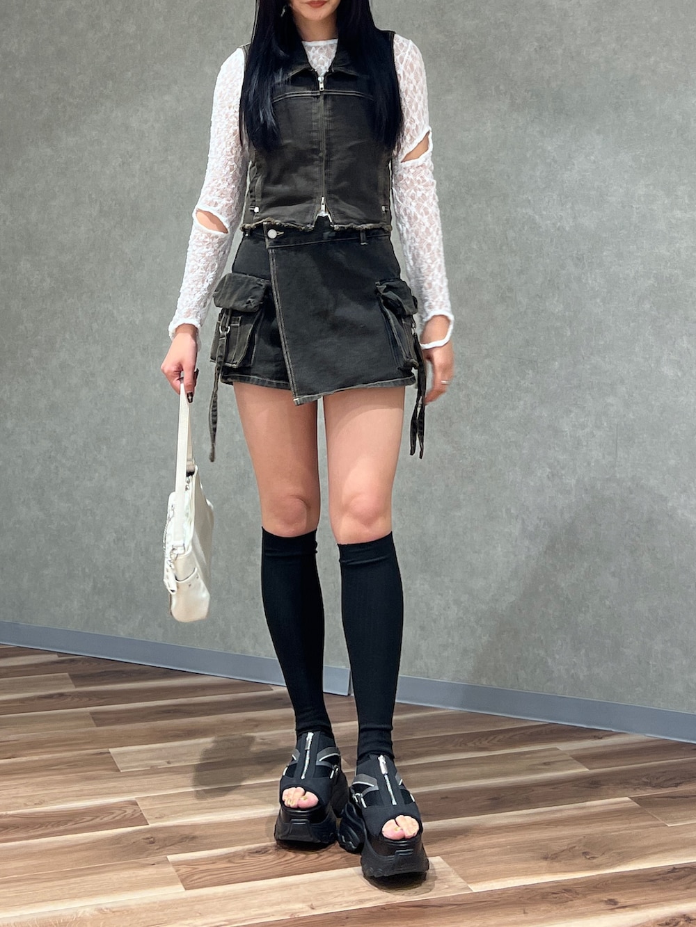 ブラック系のベスト、ブラック系のその他パンツ、ホワイト系のハンドバッグを着用したレディースの春コーディネートの4枚目の写真