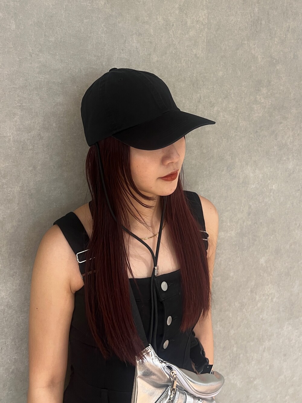 ブラック系のワンピース、ブラック系のブーツ、シルバー系のハンドバッグを着用したレディースの春コーディネートの6枚目の写真