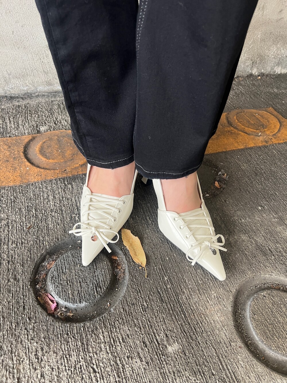 ブラック系のサロペット/オーバーオール、ブラック系のシャツ/ブラウス、ホワイト系のハンドバッグを着用したレディースの春コーディネートの6枚目の写真