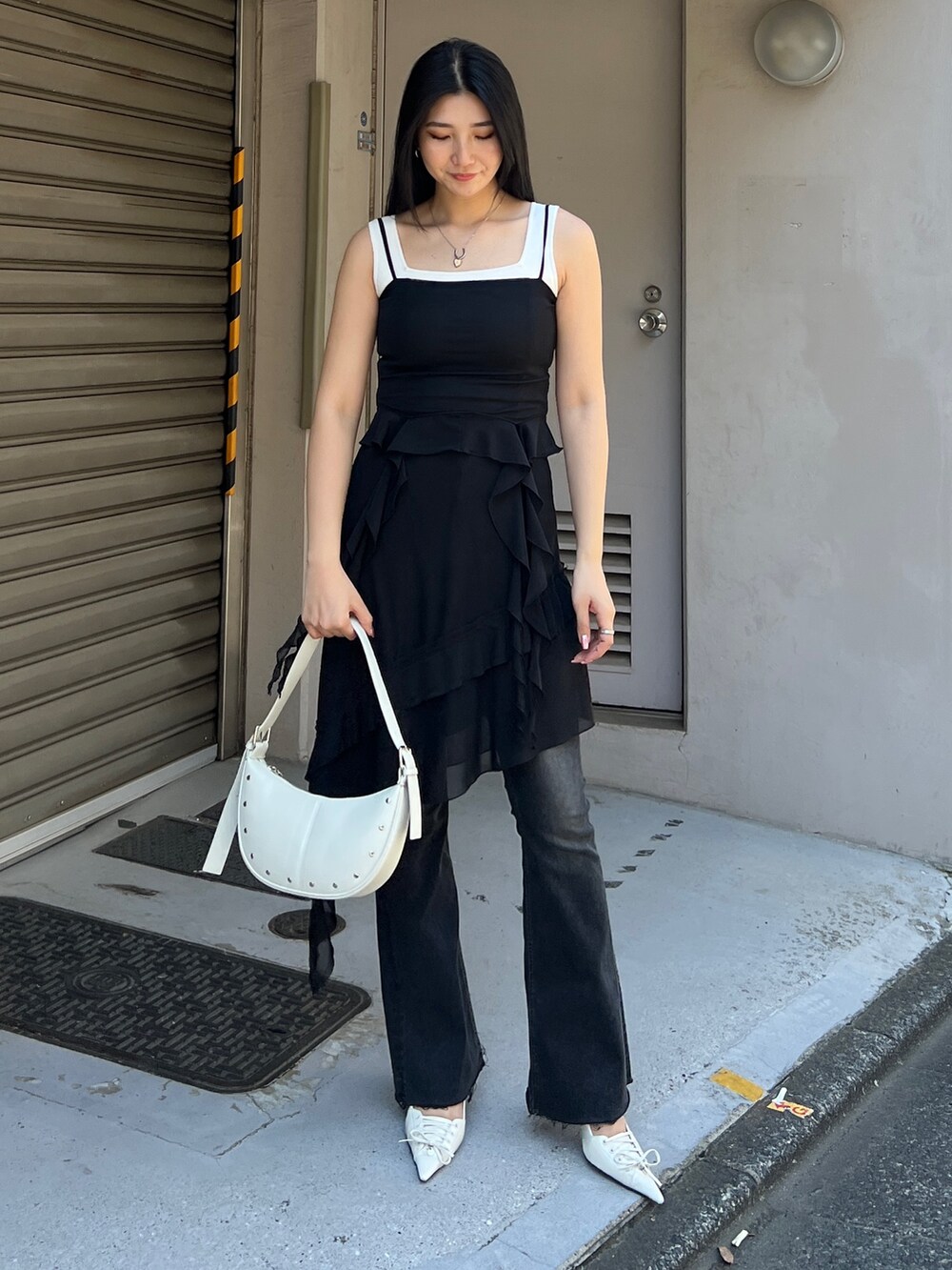 ブラック系のTシャツ/カットソー、ブラック系のスカート、ブラック系のデニムパンツを着用したレディースの春コーディネートの2枚目の写真