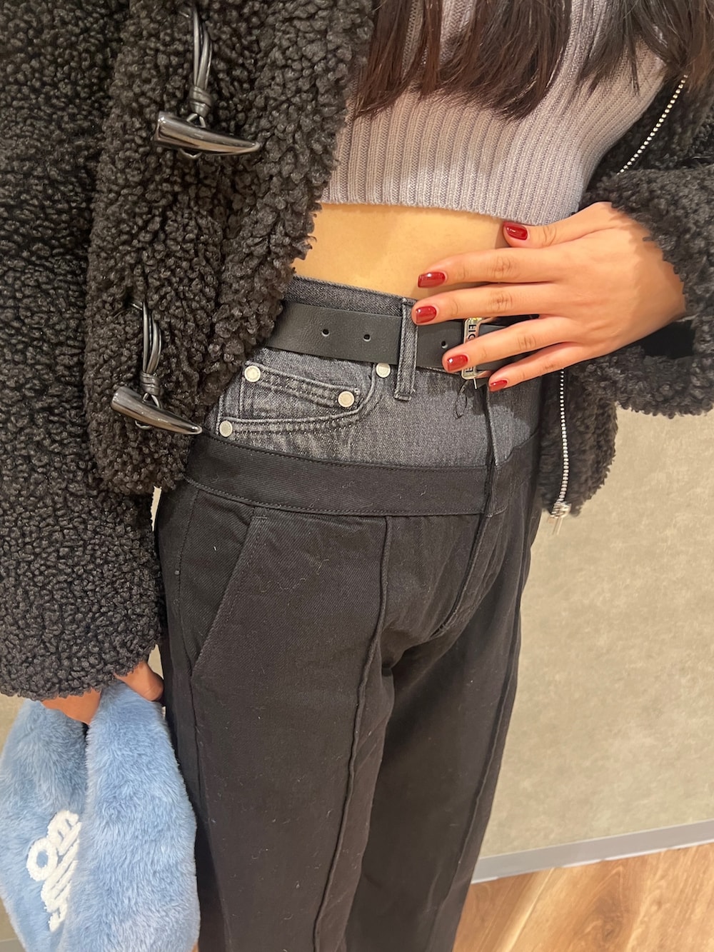 グレー系のニット/セーター、ブルー系のハンドバッグ、ブラック系のブルゾンを着用したレディースの冬コーディネートの5枚目の写真