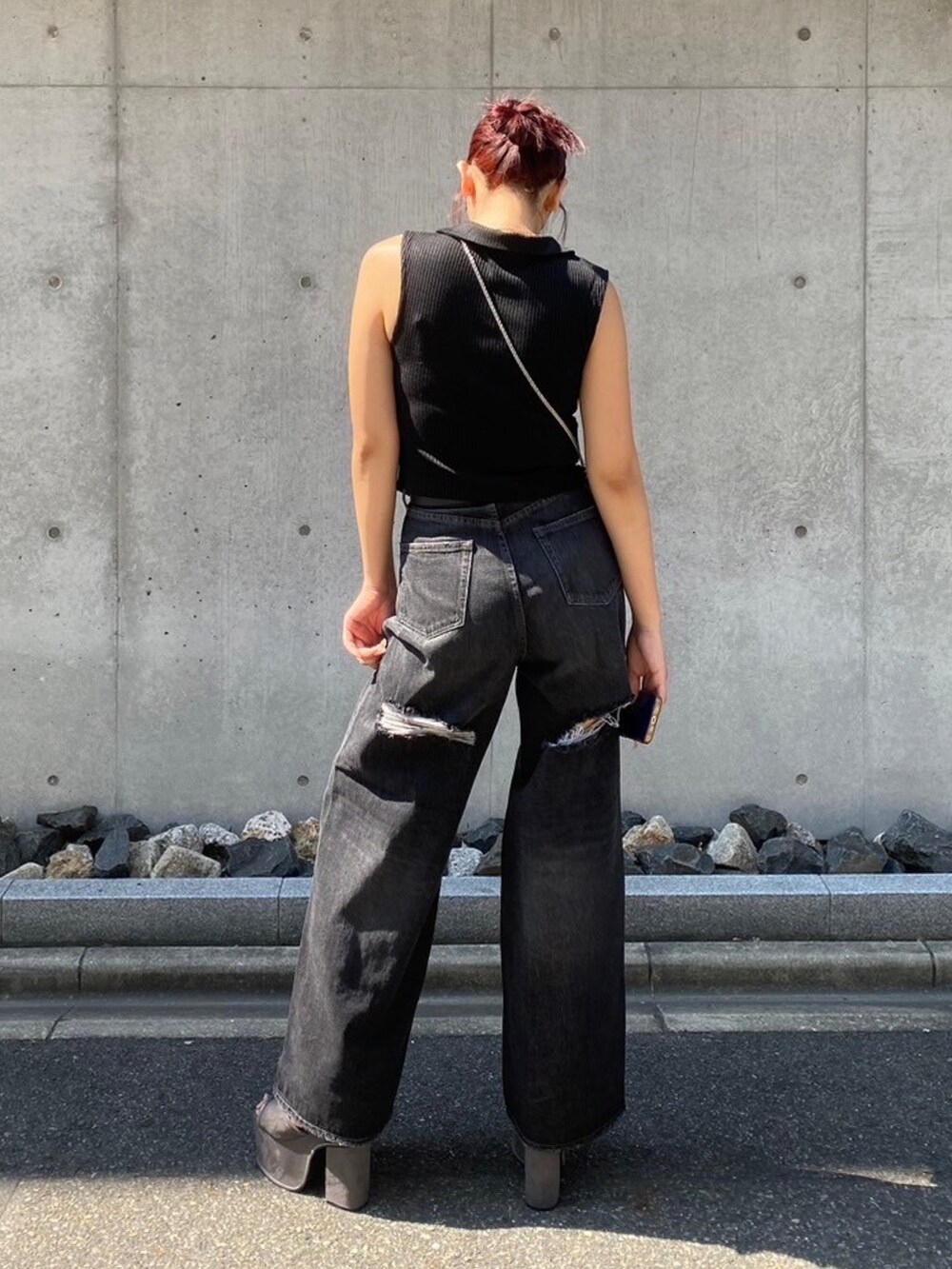 ブラック系のタンクトップ、ブラック系のデニムパンツ、グレー系のハンドバッグを着用したレディースの夏コーディネートの3枚目の写真
