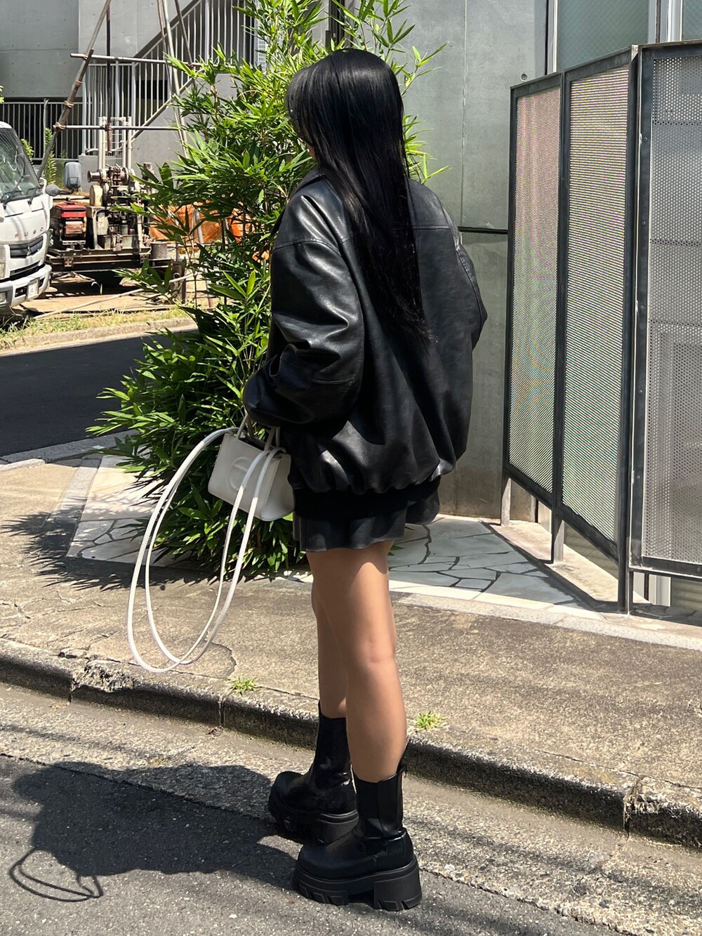ブラック系のブルゾン、ブラック系のスカート、ブラック系のブーツを着用したレディースの秋コーディネートの3枚目の写真