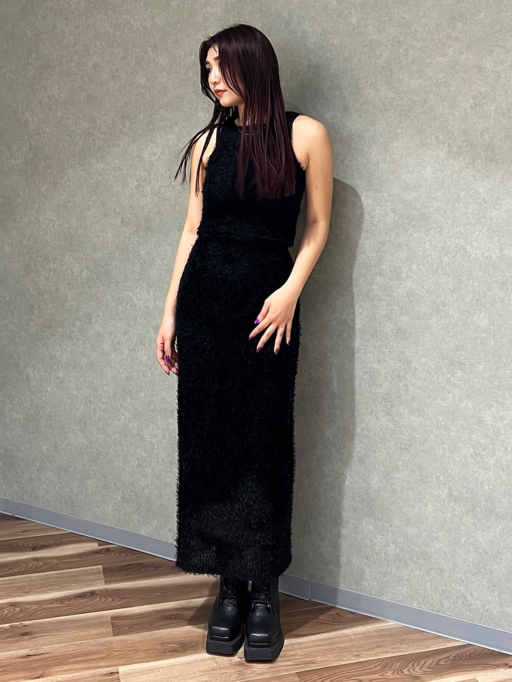 ブラック系のタンクトップ、ブラック系のスカート、ブラック系のブーツを着用したレディースの春コーディネートの3枚目の写真