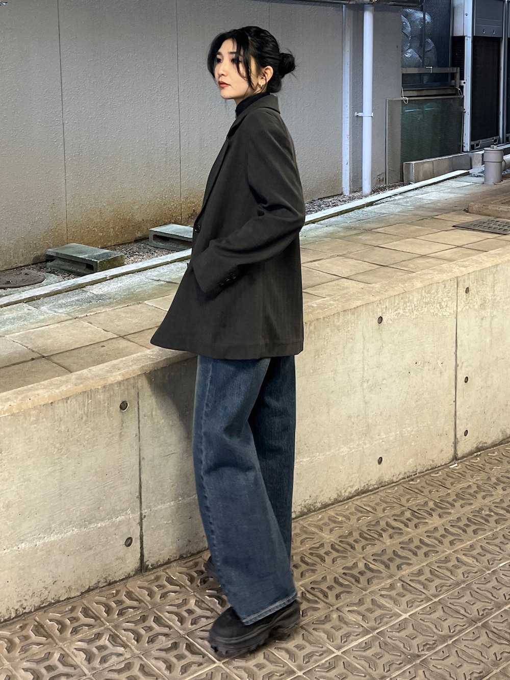 グレー系のテーラードジャケット、ブラック系のニット/セーター、ブルー系のデニムパンツを着用したレディースの冬コーディネートの2枚目の写真