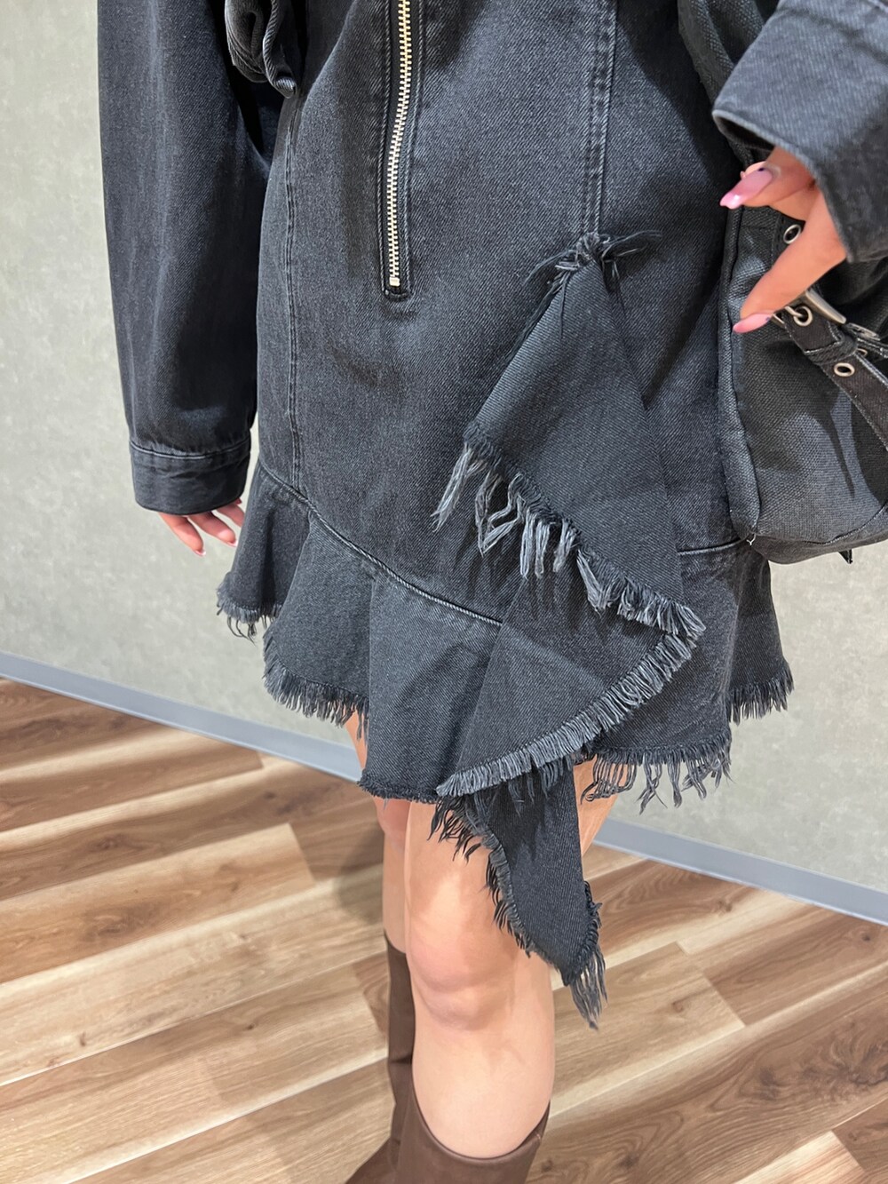 ブラック系のワンピース、ブラック系のデニムジャケット、ブラウン系のブーツを着用したレディースの冬コーディネートの6枚目の写真