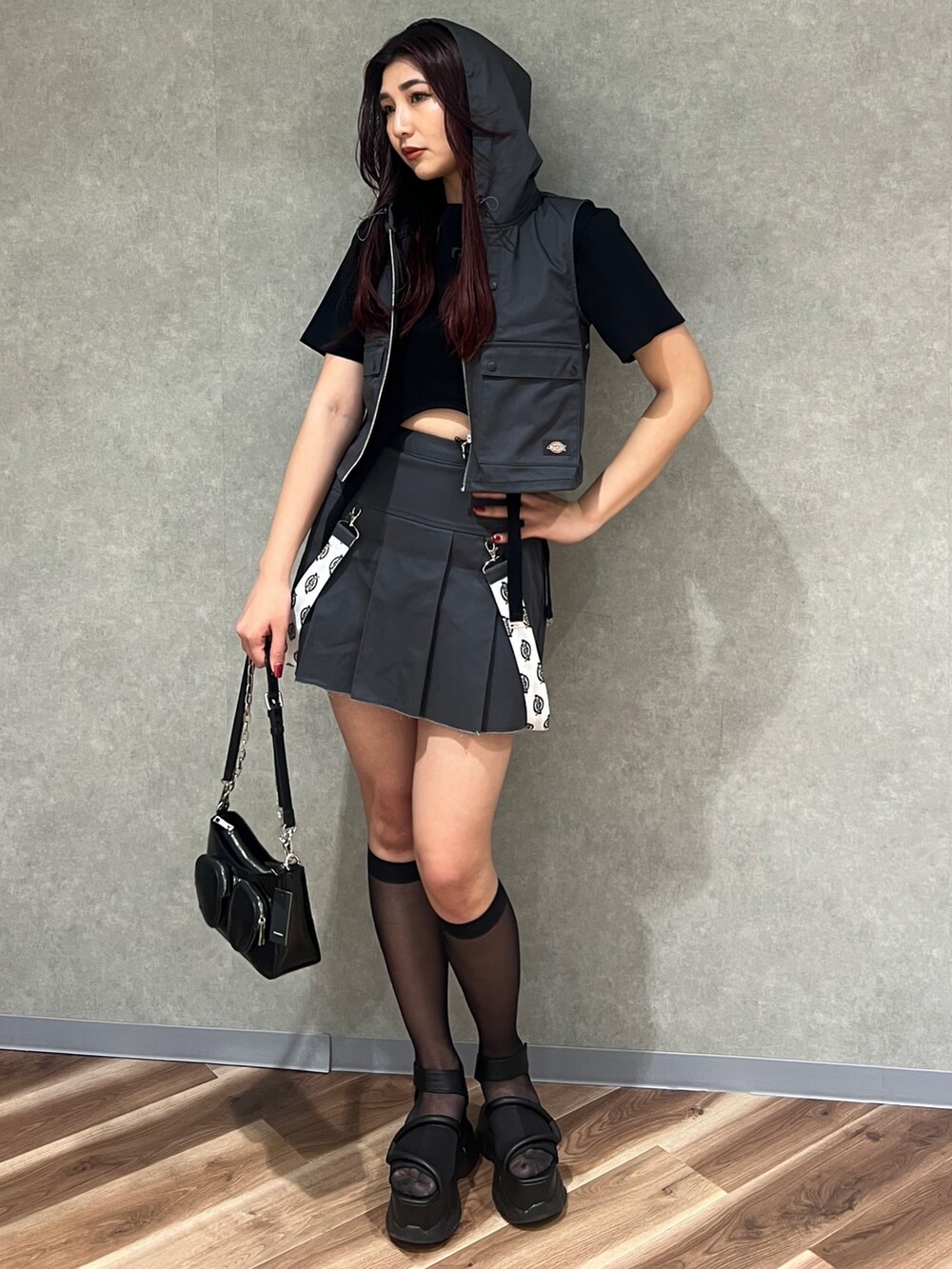 グレー系のベスト、ブラック系のTシャツ/カットソー、グレー系のスカートを着用したレディースの春コーディネートの2枚目の写真