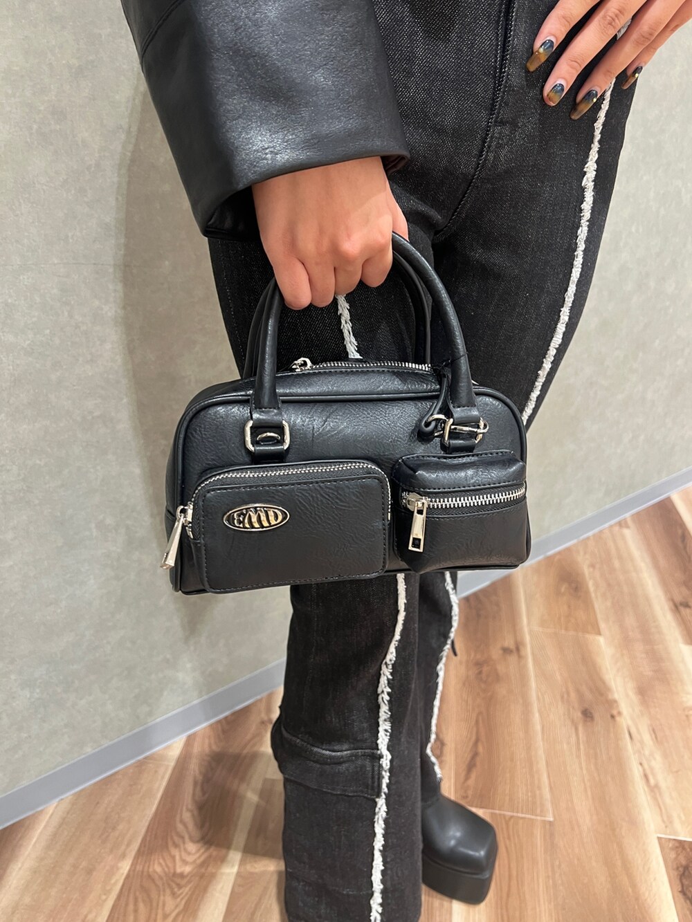 ブラック系のブルゾン、ブルー系のニット/セーター、ブラック系のデニムパンツを着用したレディースの秋コーディネートの6枚目の写真