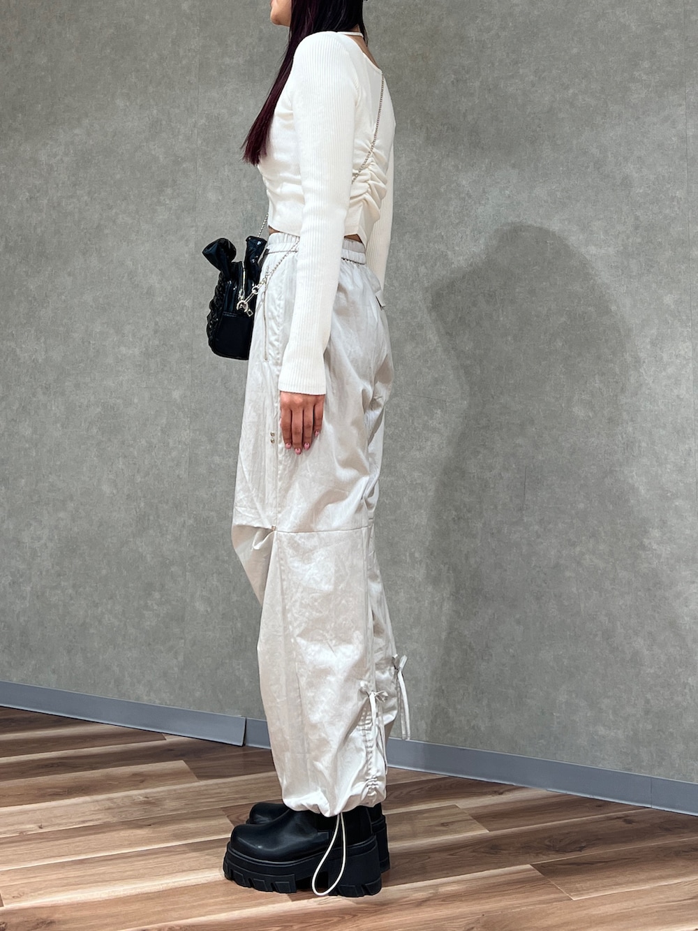 ホワイト系のニット/セーター、ホワイト系のその他パンツ、ブラック系のハンドバッグを着用したレディースの冬コーディネートの3枚目の写真