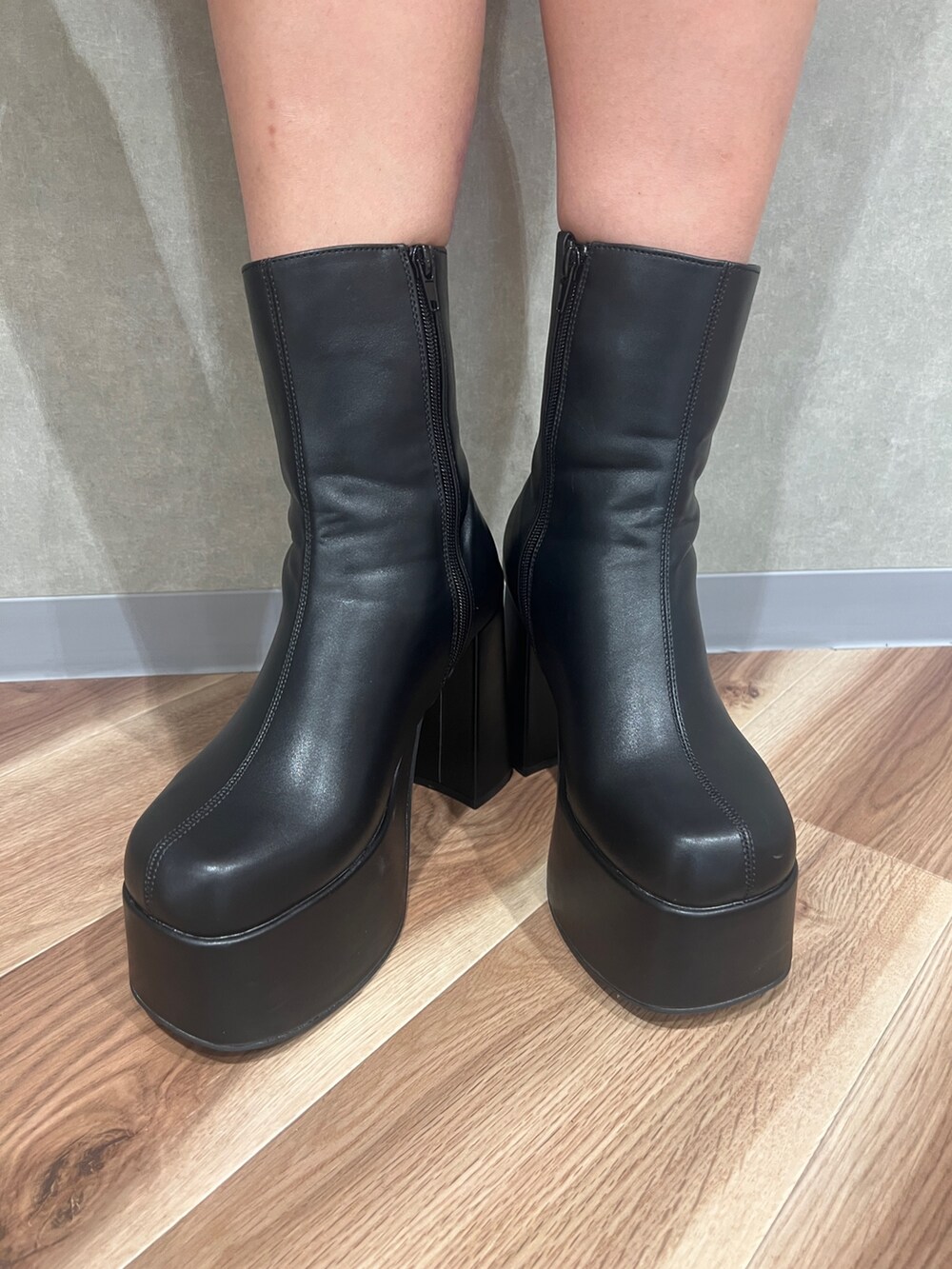 ブラック系のワンピース、ブラック系のブーツ、ホワイト系のハンドバッグを着用したレディースの秋コーディネートの7枚目の写真